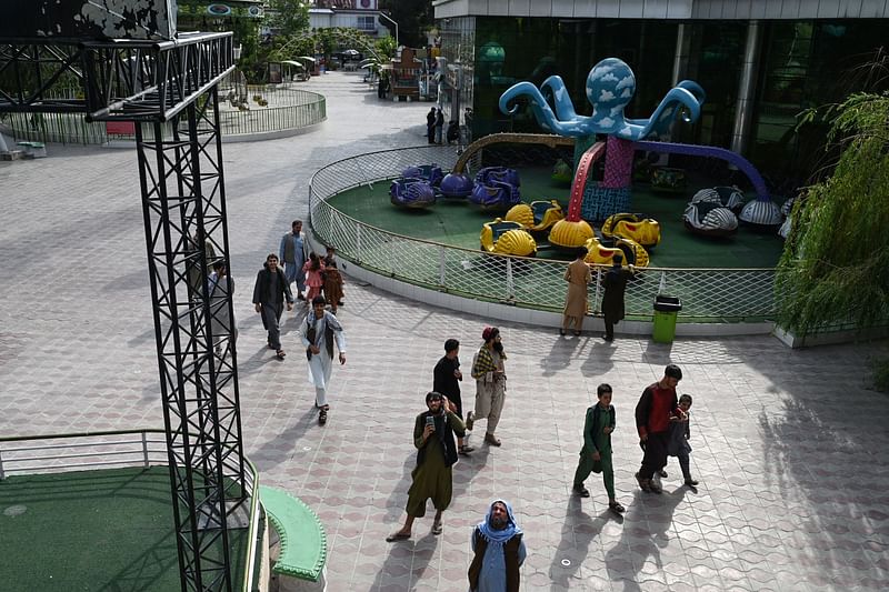 In this photo taken on 19 July 2024, men walk in an amusement park in Kabul